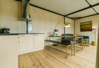 Salon moderne et cuisine avec parquet au Huus van Hanse, maison nature au parc De Klepperstee, Pays-Bas.