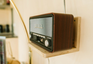Retro houten radio aan de muur in Huus van Hanse, De Klepperstee vakantiepark, Nederland.
