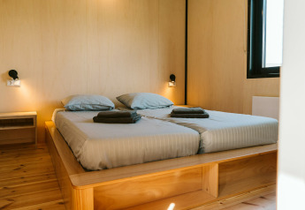 Modernes Schlafzimmer mit Doppelbett, Holzinterieur und großen Fenstern im Huus van Hanse, De Klepperstee, Niederlande.