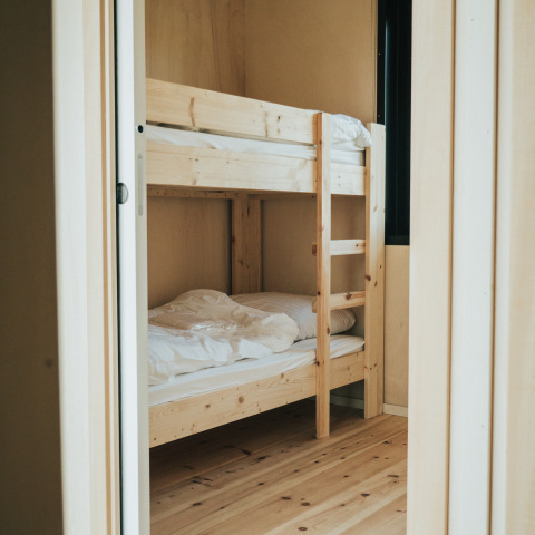 Licht houten stapelbed in een gezellige kamer van Huus van Hanse, natuurhuisje op De Klepperstee, Nederland.