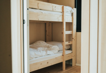 Licht houten stapelbed in een knusse kamer van Huus van Hanse, natuurhuisje op vakantiepark De Klepperstee.