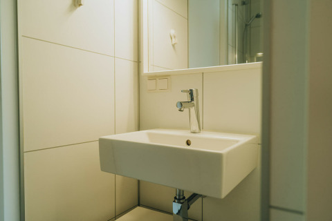 Moderne wastafel en spiegel in de badkamer van Duunroos, een lodge in vakantiepark De Klepperstee, Nederland.