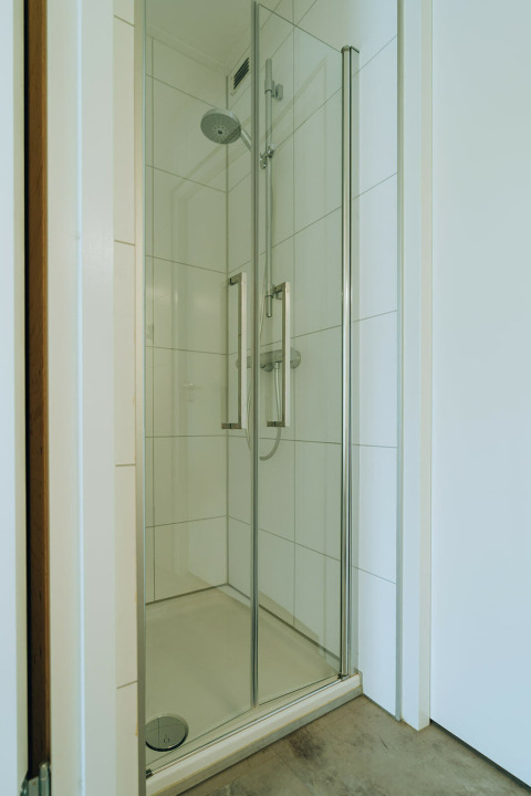 Moderne Duschkabine mit Glastüren in Duunroos, einer Lodge im Ferienpark De Klepperstee, Niederlande.