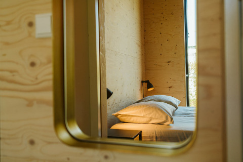 Reflejo en el espejo de un acogedor dormitorio en la cabaña Kleproos, Holiday park De Klepperstee, Países Bajos.