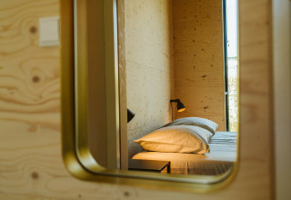 Spiegelreflectie van een knusse slaapkamer in Kleproos lodge, Holiday park De Klepperstee, Nederland.