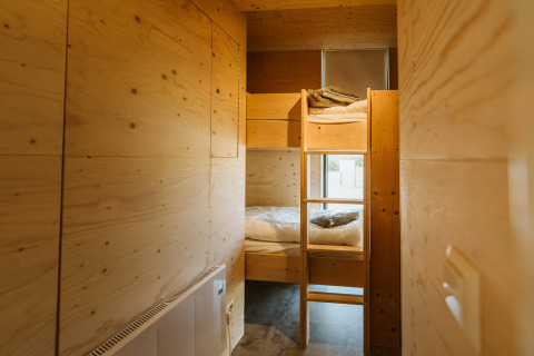 Sfeervolle houten stapelbedden in een Kleproos lodge op vakantiepark De Klepperstee, Nederland.