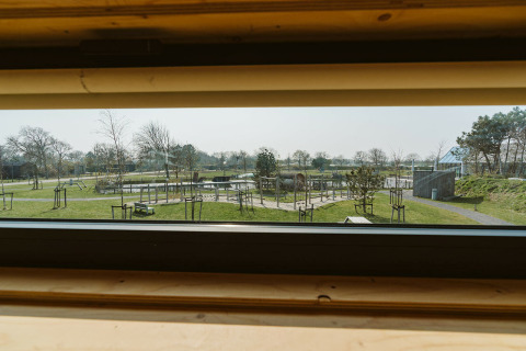 Vue depuis une fenêtre du lodge Kleproos au parc de vacances De Klepperstee avec espaces verts aux Pays-Bas.