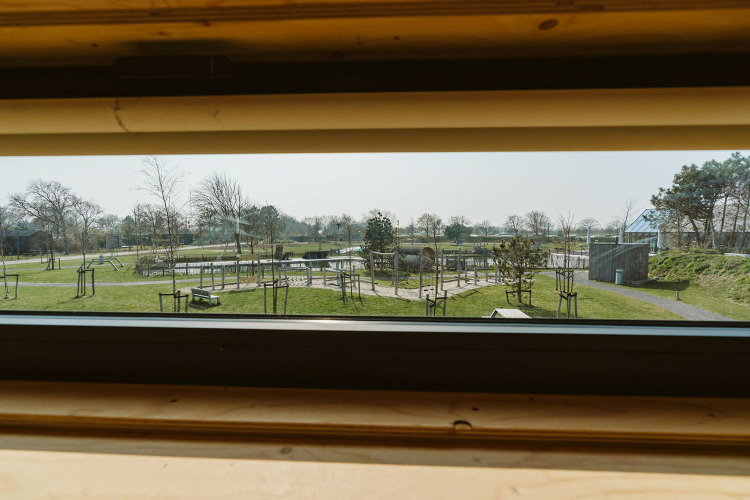 View from a window at Kleproos lodge in Holiday park De Klepperstee with green areas in the Netherlands.