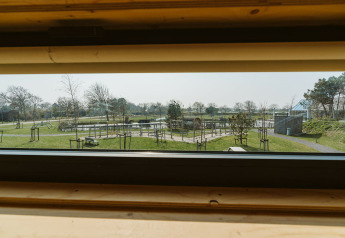 Vue depuis une fenêtre du lodge Kleproos au parc de vacances De Klepperstee avec espaces verts aux Pays-Bas.