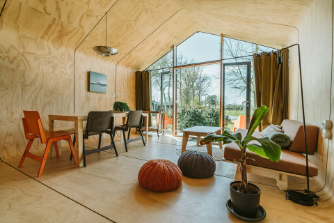 Lyst interiør af Oep naturhus ved Holiday park De Klepperstee, med store vinduer og moderne møbler.