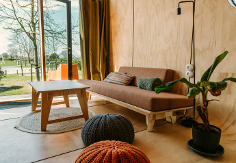 Salon lumineux moderne à Oep, maison nature du Holiday park De Klepperstee, Pays-Bas, avec vue sur l'extérieur.