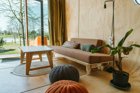 Bright, modern living room at Oep, a nature house at Holiday park De Klepperstee in the Netherlands, view outside.