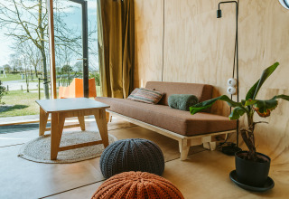 Lichte, moderne woonkamer in Oep, een natuurhuisje op vakantiepark De Klepperstee in Nederland met uitzicht.