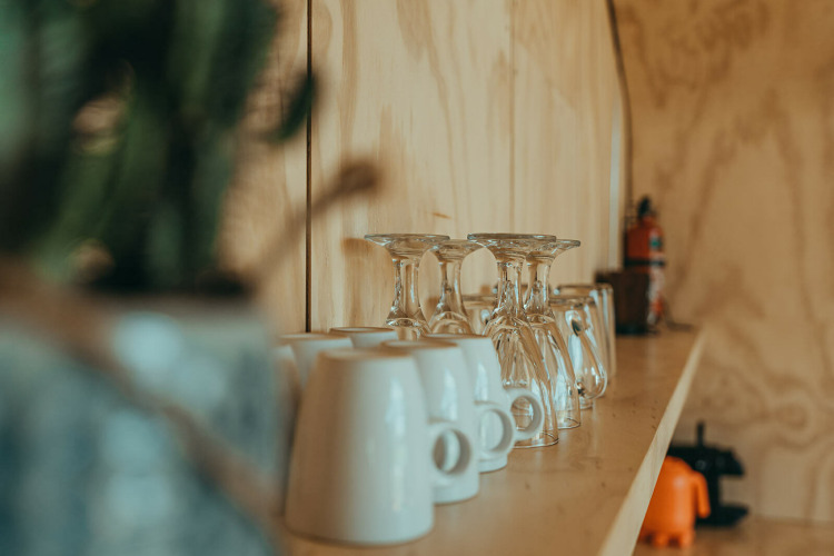 Estante con vasos y tazas en una casa natural en el parque vacacional De Klepperstee en los Países Bajos.