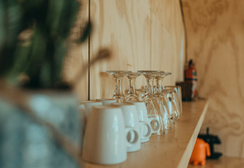 Estante con vasos y tazas en una casa natural en el parque vacacional De Klepperstee en los Países Bajos.