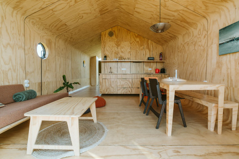 Vista interior de Oep, una casa de naturaleza en el parque De Klepperstee, Países Bajos, con muebles de madera.