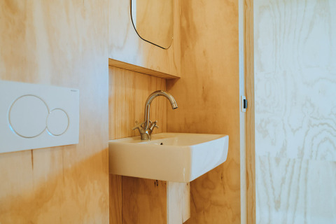 Baño minimalista con lavabo y grifo moderno en Oep, casa de naturaleza en De Klepperstee, Países Bajos.