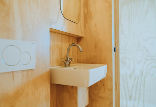 Baño minimalista con lavabo y grifo moderno en Oep, casa de naturaleza en De Klepperstee, Países Bajos.