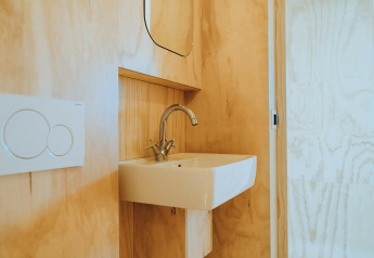 Baño minimalista con lavabo y grifo moderno en Oep, casa de naturaleza en De Klepperstee, Países Bajos.