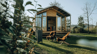 Wikkelhouse Bear, une maison nature au Holiday park De Klepperstee aux Pays-Bas, avec des chaises dehors.