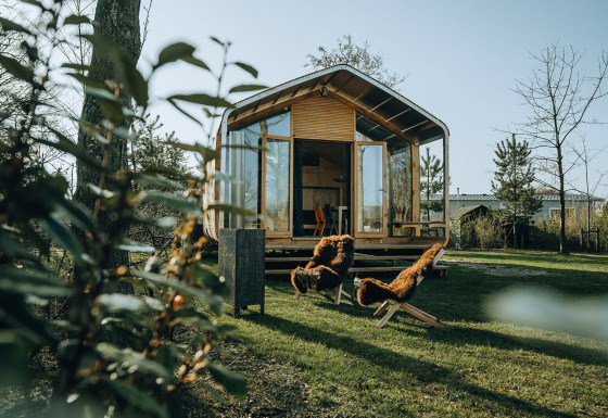 Wikkelhouse Bear, een natuurhuis in vakantiepark De Klepperstee in Nederland met stoelen buiten.