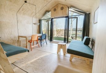Lichte en moderne woonkamer in Wikkelhouse Bear, Holiday park De Klepperstee, Nederland met grote ramen.