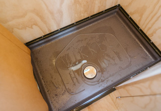 Binnenaanzicht van een douche met 'Wikkel House' in het water geschreven, Wikkelhouse Bear, Nederland.