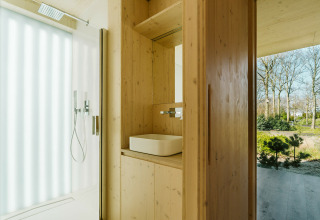Baño moderno de madera en Ark Shelter, una casa de naturaleza en Holiday park De Klepperstee, Países Bajos.