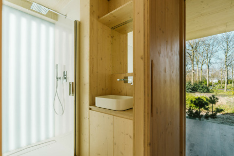 Baño moderno de madera en Ark Shelter, una casa de naturaleza en Holiday park De Klepperstee, Países Bajos.