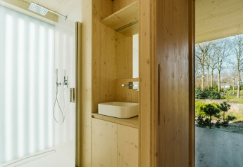 Baño moderno de madera en Ark Shelter, una casa de naturaleza en Holiday park De Klepperstee, Países Bajos.