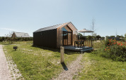 Casa tiny house moderna en el parque vacacional De Klepperstee en los Países Bajos con terraza.
