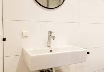 Évier blanc moderne avec miroir dans la mini-maison Stulp, Holiday park De Klepperstee, Pays-Bas.