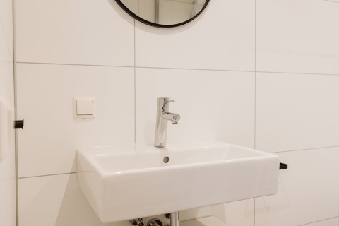 Évier blanc moderne avec miroir dans la mini-maison Stulp, Holiday park De Klepperstee, Pays-Bas.