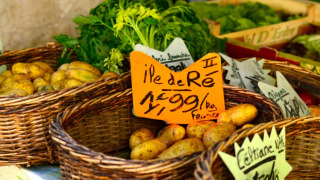 Patatas frescas y verduras en cestas en un mercado cerca de Eco domaine Le Camp en Occitanie, Francia.