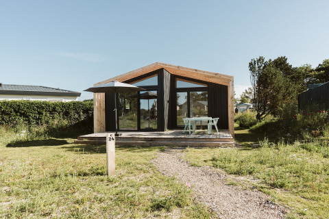Et moderne naturhus med store glasvinduer og træterrasse på Holiday park De Klepperstee i Nederlandene.