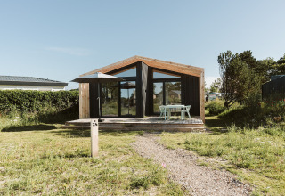 Una moderna casa de naturaleza con grandes ventanales y terraza en Holiday park De Klepperstee, Países Bajos.