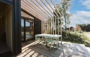 Buitenterras aan Nature house Barn op Holiday park De Klepperstee, Nederland, met houten tafel en stoelen