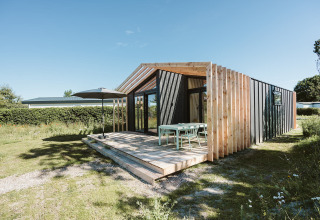 Moderne træhytte ved De Klepperstee feriested i Holland med udendørs terrasse og have.