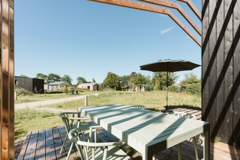 Zona pranzo all'aperto con ombrellone presso Barn, Nature house, Holiday park De Klepperstee, Paesi Bassi.