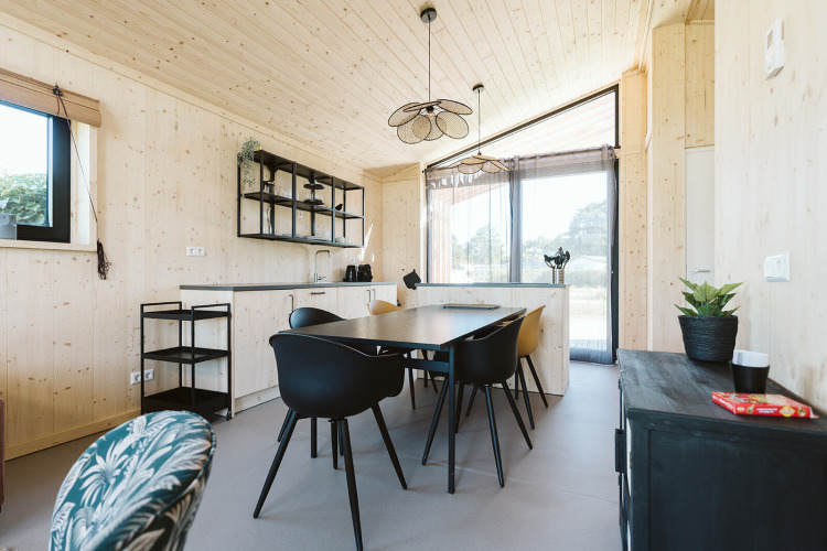 Moderne, lichte eetruimte en keuken in een natuurhuisje op Vakantiepark De Klepperstee, Nederland.