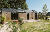 Moderna casa tiny de madera en Holiday park De Klepperstee, Países Bajos, con terraza y naturaleza alrededor.