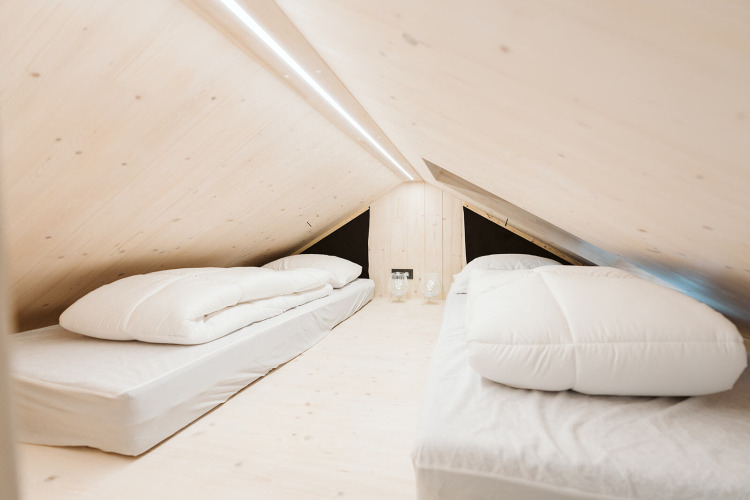 Minimalistische loftslaapkamer met twee eenpersoonsbedden en licht hout bij Punt, De Klepperstee, Nederland.