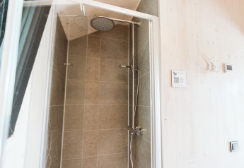 Dusche im Punt-Tiny House im Holiday Park De Klepperstee in den Niederlanden mit moderner Fliesenwand.