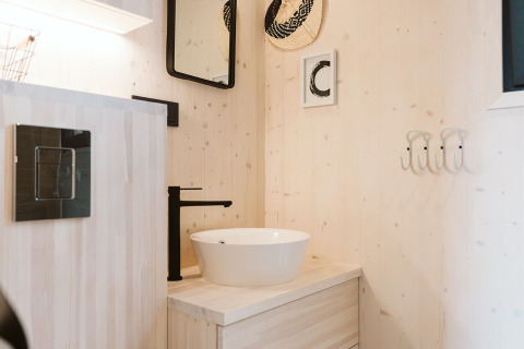 Baño moderno con lavabo de sobreponer y grifo negro en una tiny house en Holiday park De Klepperstee, Países Bajos.