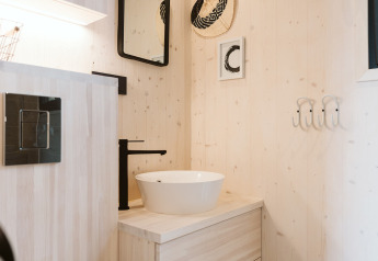 Bagno moderno con lavabo da appoggio e rubinetto nero in una tiny house nel Holiday park De Klepperstee, Paesi Bassi.
