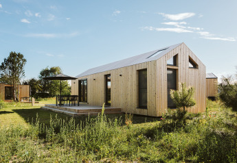 Moderne tiny house bij vakantiepark De Klepperstee in Melle, Nederland, met houten gevel en terras.