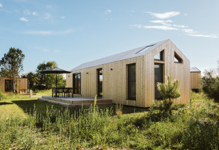 Modern tiny house at Holiday park De Klepperstee in Melle, Netherlands, with wooden exterior and patio.