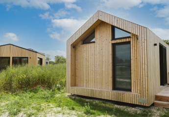 Moderne tiny house bij vakantiepark De Klepperstee in Melle, Nederland, omgeven door natuur.