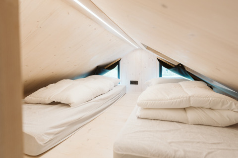 Deux lits simples sous un toit en pente dans la Tiny House Melle, parc De Klepperstee, Pays-Bas.