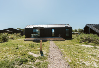 Moderne tiny house Est bij Vakantiepark De Klepperstee in Nederland, omgeven door gras.